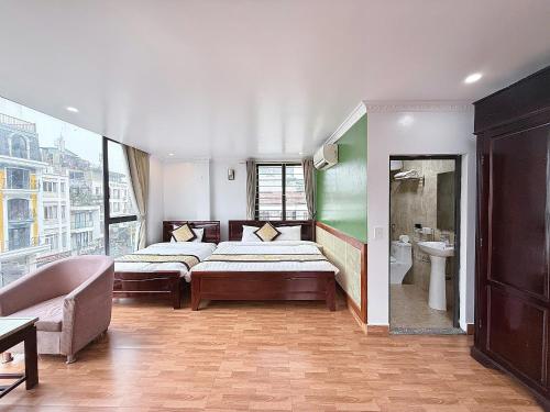a bedroom with two beds and a couch and a sink at Sweden SaPa Hotel in Sapa