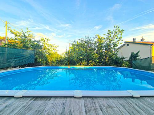 a large blue swimming pool on a wooden deck at Ca di Borra - Orto Bio e Piscina in Rofelle