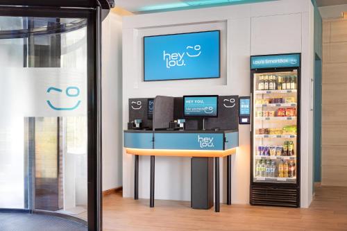 a cashier counter in a store with a refrigerator at Hey Lou Hotel Friedrichshafen in Friedrichshafen