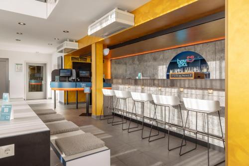 a bar in a restaurant with white chairs at Hey Lou Hotel Nördlingen in Nördlingen