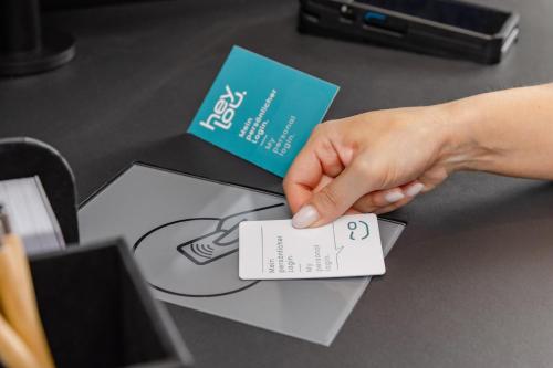 a hand is holding a card on a table at Hey Lou Hotel Hildesheim in Hildesheim