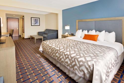 a hotel room with a large bed and a chair at Wingate by Wyndham - Arlington Heights in Arlington Heights