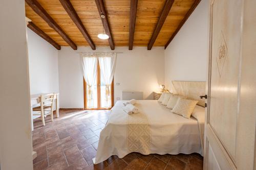 a bedroom with a bed with a wooden ceiling at Agriturismo Cirra in Tertenìa