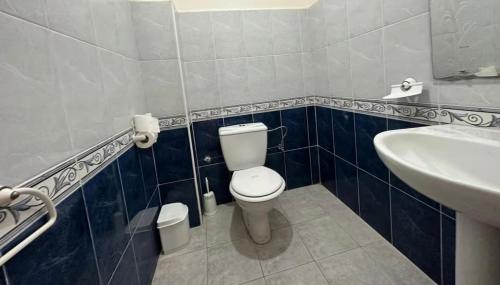 a bathroom with a white toilet and a sink at Beautiful Duplex in secure residence with 2 pools in Sidi Bouzid