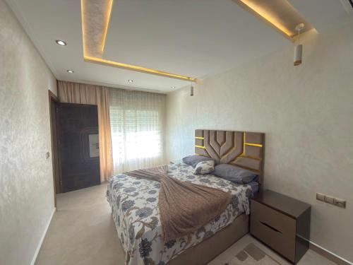 a bedroom with a large bed and a large window at Appartement à plage Dalia in Dalia