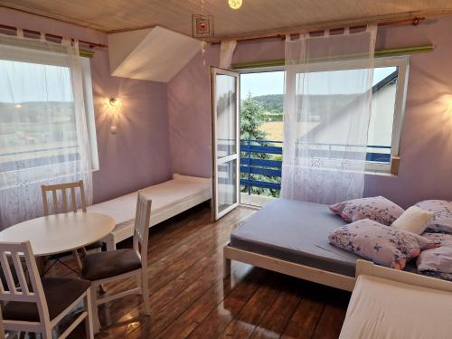 ein kleines Zimmer mit einem Bett, einem Tisch und einem Fenster in der Unterkunft Willa Elf in Karwia