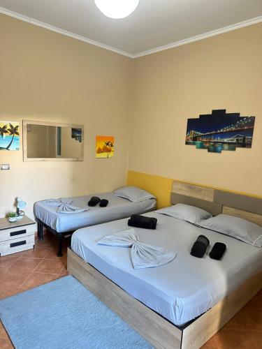 two twin beds in a room with a mirror at Guest House by Roni in Durrës