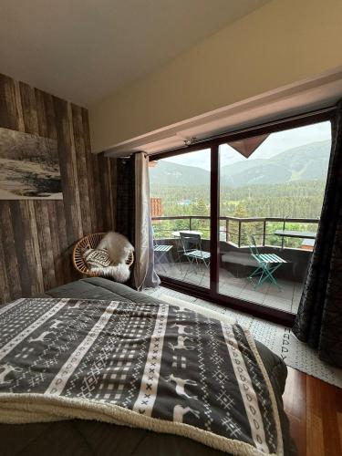 a bedroom with a bed and a large window at Apartemento en la Molina - a pie de pistas in La Molina