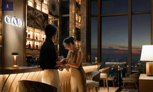 a man and woman standing in a hotel lobby at Landmark 81 Exclusive Panorama Residence in Ho Chi Minh City