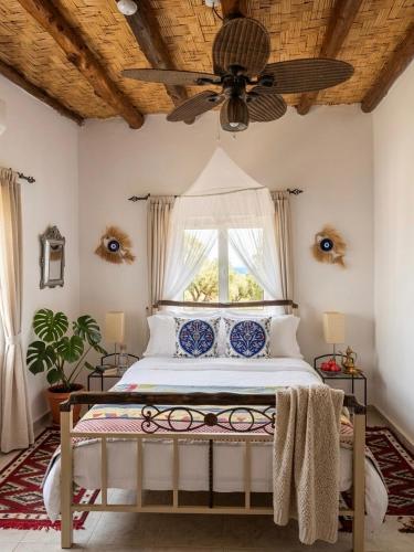 a bedroom with a bed with a ceiling fan at A historic STONE VILLA with private garden, terrace and private pool just for you in Kyrenia