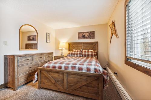 a bedroom with a bed and a dresser and a window at Tannhauser 222 in Breckenridge
