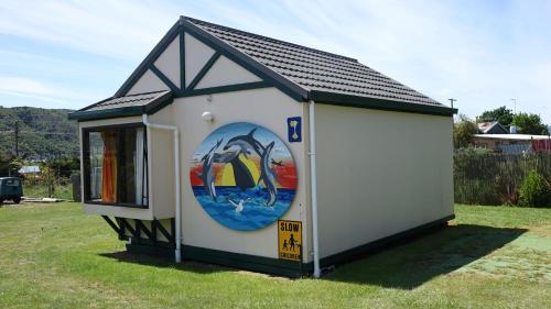 a smallshed with a painting on the side of it at Picton's Waikawa Bay Holiday Park in Picton