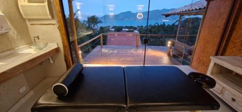 a room with a balcony with a view of the ocean at Studio Moderno com Vista pro mar com hidromassagem e churrasqueira privativas e Piscina aquecida na área comum in São Sebastião