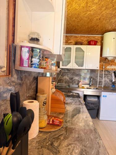 a kitchen with white cabinets and a counter top at Kosmaj Thalia in Babe