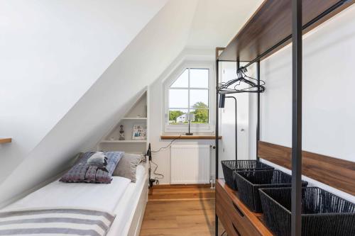 a bedroom with a bed and a window at Lütt Mööv in Wenningstedt