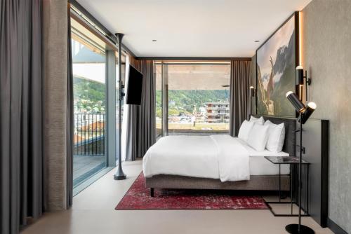 a bedroom with a bed and a large window at Radisson RED Innsbruck in Innsbruck
