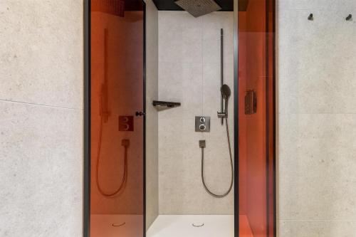 a shower in a bathroom with a glass door at Radisson RED Innsbruck in Innsbruck