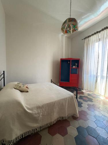 a bedroom with a white bed and a red cabinet at Dimora Corso Roma in Montecatini Terme