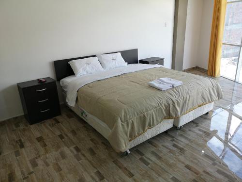 a bedroom with a large bed with two night stands at Hotel el sol Caraz in Caraz