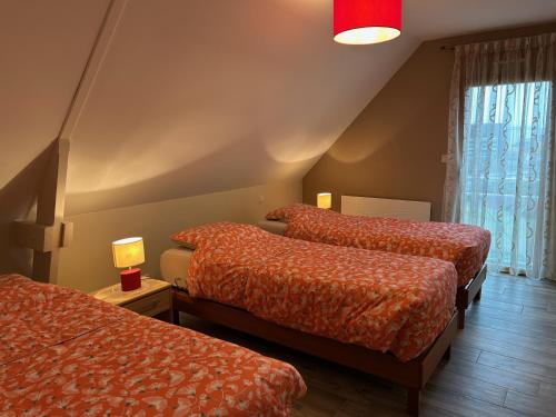 a room with two beds and a window at Chambres Saint-Jamaises in Saint-James