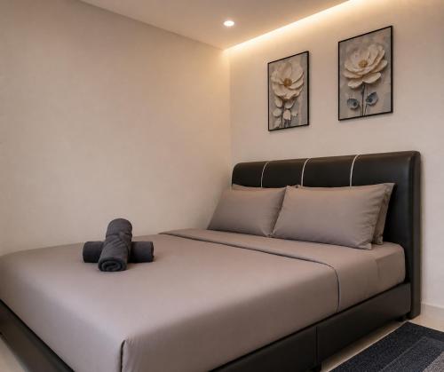 a bed with a black headboard in a room at Dmana Homestay Arau Perlis in Arau