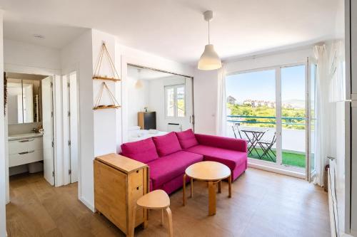 a living room with a purple couch and a table at Brisa de Usil in Mogro