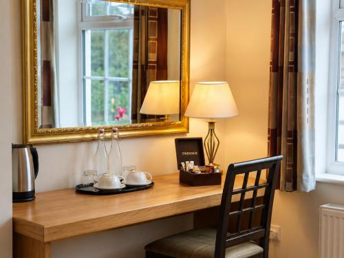 a desk with a mirror and a lamp and a chair at Stratford Limes Hotel in Stratford-upon-Avon