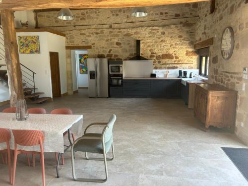 a large kitchen with a table and chairs in a room at Gîte Les Jacquets in Hautefort
