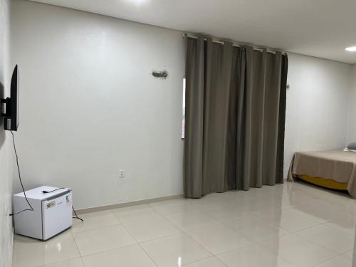 a bedroom with a bed and a window with curtains at Dormitório in Barreirinhas