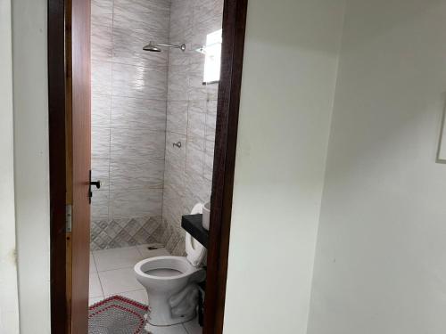 a bathroom with a toilet and a shower at Dormitório in Barreirinhas