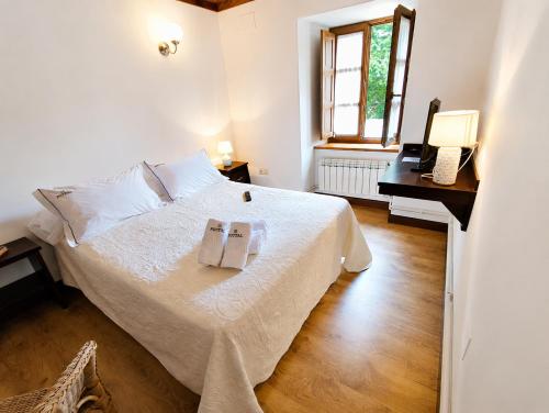 a bedroom with a bed and a desk with a phone at Airtegal Casa do Puntal in Valdoviño