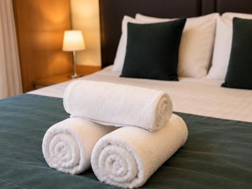 a pile of towels sitting on top of a bed at Stratford Limes Hotel in Stratford-upon-Avon