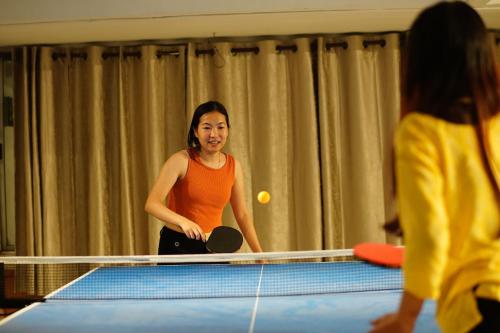 a woman playing a game of table tennis at Wanderpals Guwahati in Guwahati
