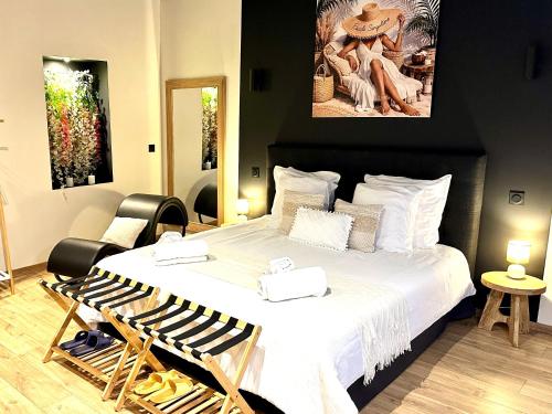 a bedroom with a large bed with white sheets at Escale Singulière - Balnéo, patio et confort 4 étoiles in Sète