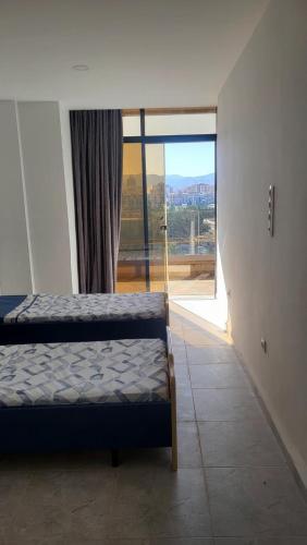 a bedroom with a bed and a large window at Appart Ilyani in El Kseur