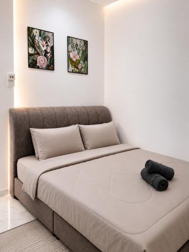 a large bed in a room with two pictures on the wall at Dmana Homestay Arau Perlis Tiny House in Arau