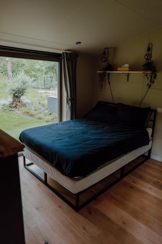 a bed in a room with a large window at Casa Lilou in Lochristi