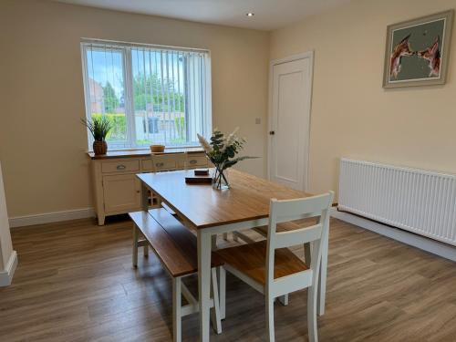 a dining room with a wooden table and chairs at Tudor House in Osgodby