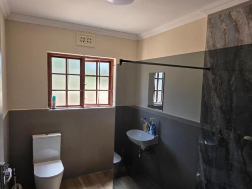 a bathroom with a toilet and a sink at Sea & Forest Self Catering Estate - Durban Kingsburgh in Kingsborough