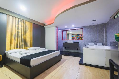 a bedroom with a bed and a tub and a sink at Hotel Kalifornia in Bello