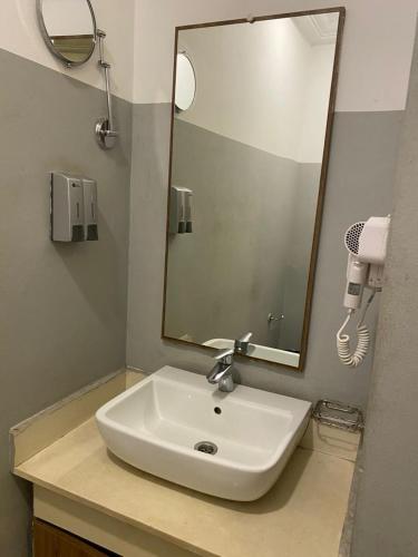 a bathroom with a sink and a mirror at Peach City Hotel in Prampram