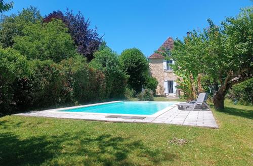 a swimming pool in the yard of a house at Villa EsquirHall, chambres d'hôtes in Journiac
