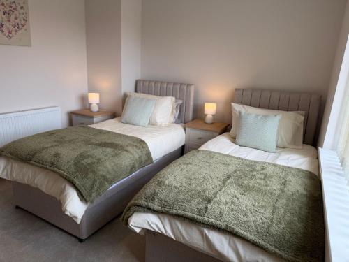two beds sitting next to each other in a bedroom at Tudor House in Osgodby
