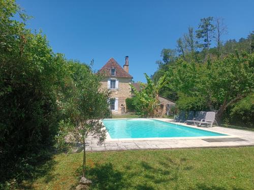 a swimming pool in front of a house at Villa EsquirHall, chambres d'hôtes in Journiac