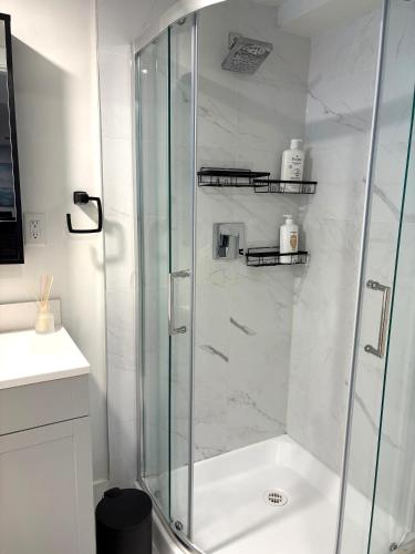 a shower with a glass door in a bathroom at Brookswood Oasis - Guest suite,1 bedroom,1 den & 1 full bathroom in Langley