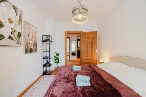 a bedroom with a large bed with two towels on it at Altbau-Traum, Zentrumsnah, Küche, Whirlpool in Braunschweig