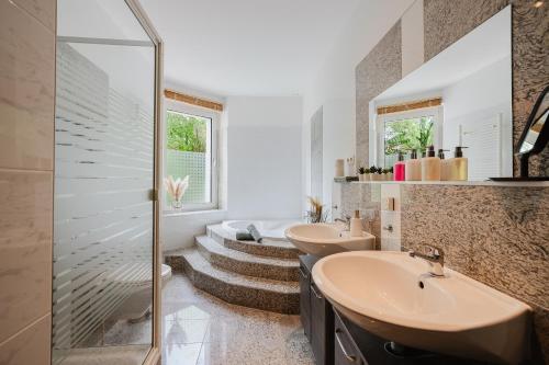 a bathroom with two sinks and a walk in shower at Altbau-Traum, Zentrumsnah, Küche, Whirlpool in Braunschweig