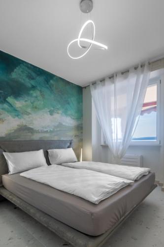 a bedroom with a large bed and a painting at Garda Dolce Vita in Torri del Benaco