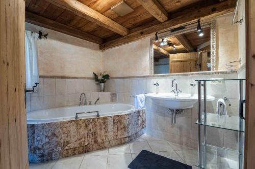 a bathroom with a tub and a sink at Panorama Alm Chalets by we rent JOKERCARD INCLUDED in Saalbach-Hinterglemm
