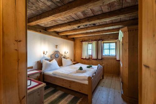 a bedroom with a large bed in a wooden house at Panorama Alm Chalets by we rent JOKERCARD INCLUDED in Saalbach-Hinterglemm